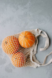 Mesh shopping bag with vegetables. autumn pumpkin harvest