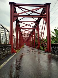 Bridge over empty road against sky