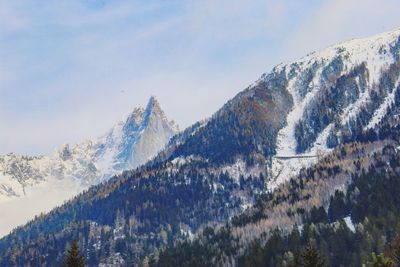 Low angle view of snowcapped mountains against sky