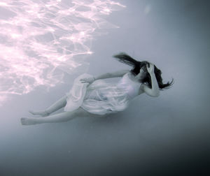 High angle view of beautiful woman wearing dress floating undersea