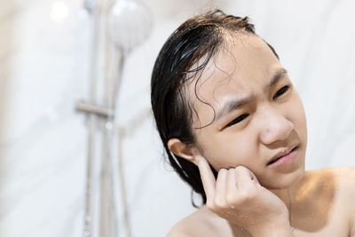 Close-up portrait of woman in bathroom