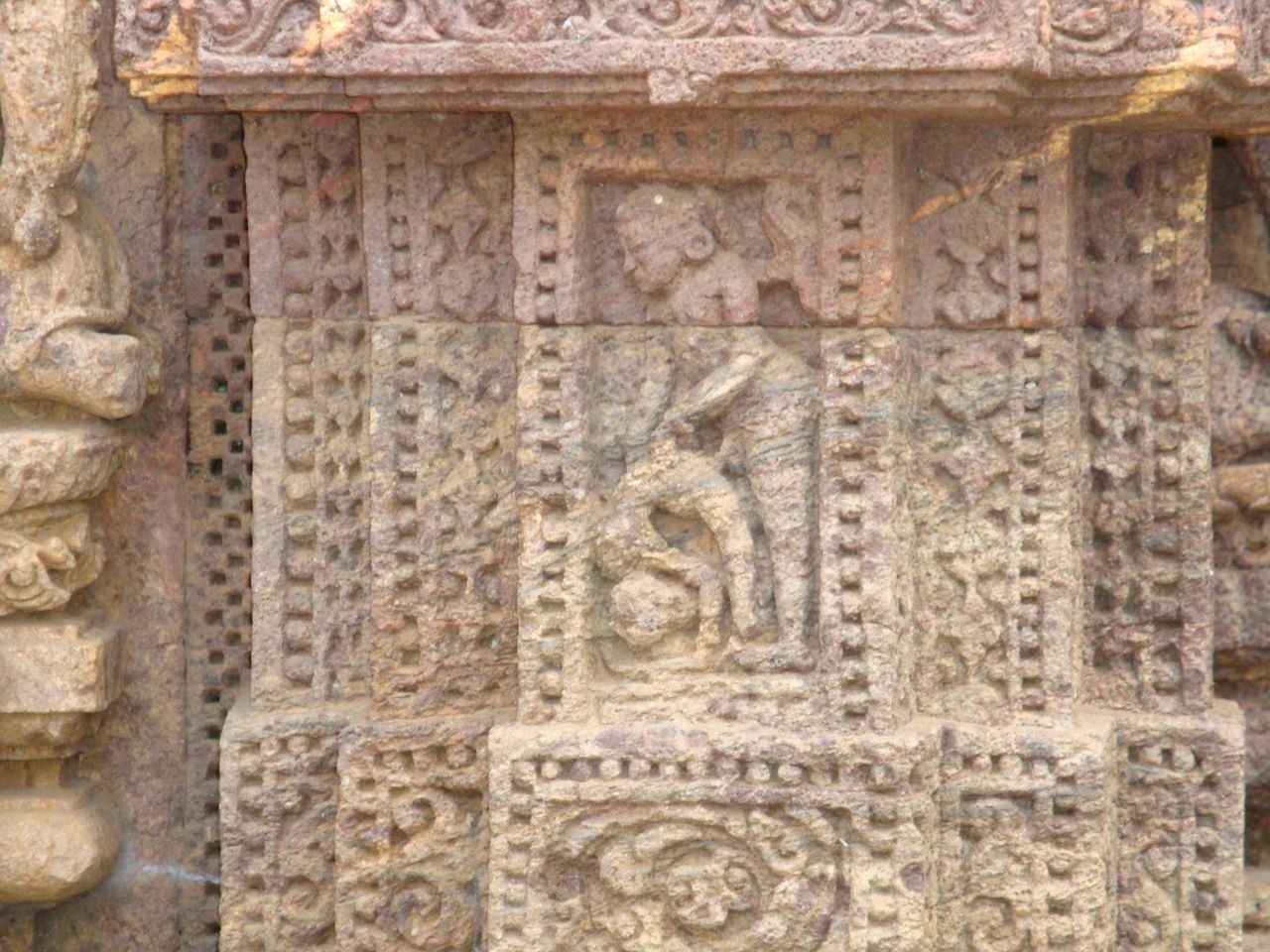 CLOSE-UP OF ORNATE CARVING ON WALL OF BUILDING