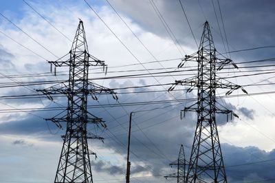 Low angle view of electricity pylon against sky