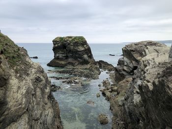 Rock formation on beach against sky