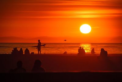 Silhouette people on beach during sunset