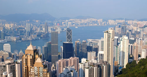 Aerial view of river amidst modern buildings against sky