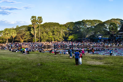 Crowd enjoying in park against sky