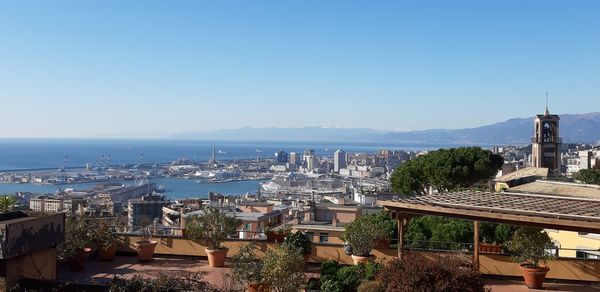 High angle view of buildings in city against clear blue sky