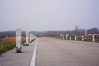 Walkway by road against clear sky