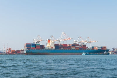 Commercial dock by sea against clear sky