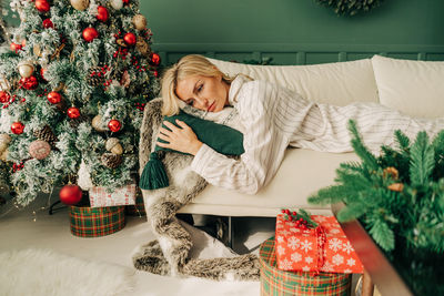 Frustrated depressive sad sick woman in pajamas lies on the sofa in christmas alone. holidays 