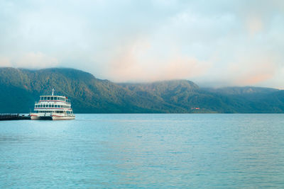 Tourist boat docked in lake towada, japan. early morning scene by the lake.