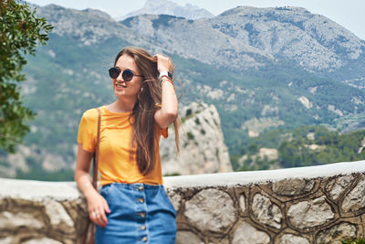 Young woman wearing sunglasses standing on mountain