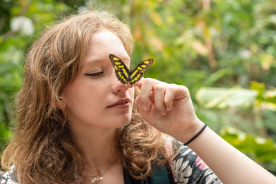 Girl holds butterfly on her nose