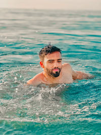 Young man swimming in sea
