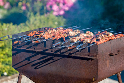 Shish kebab is fried on a brazier. there is smoke. brazier rusty.