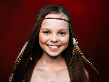 Portrait of smiling girl against black background