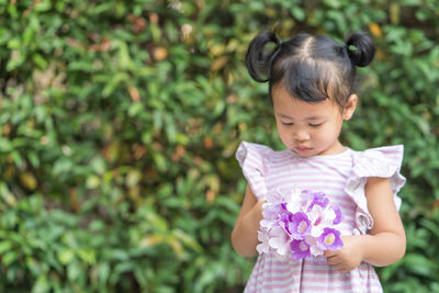 Cute girl standing against plants