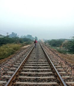 Railroad tracks against sky during foggy weather