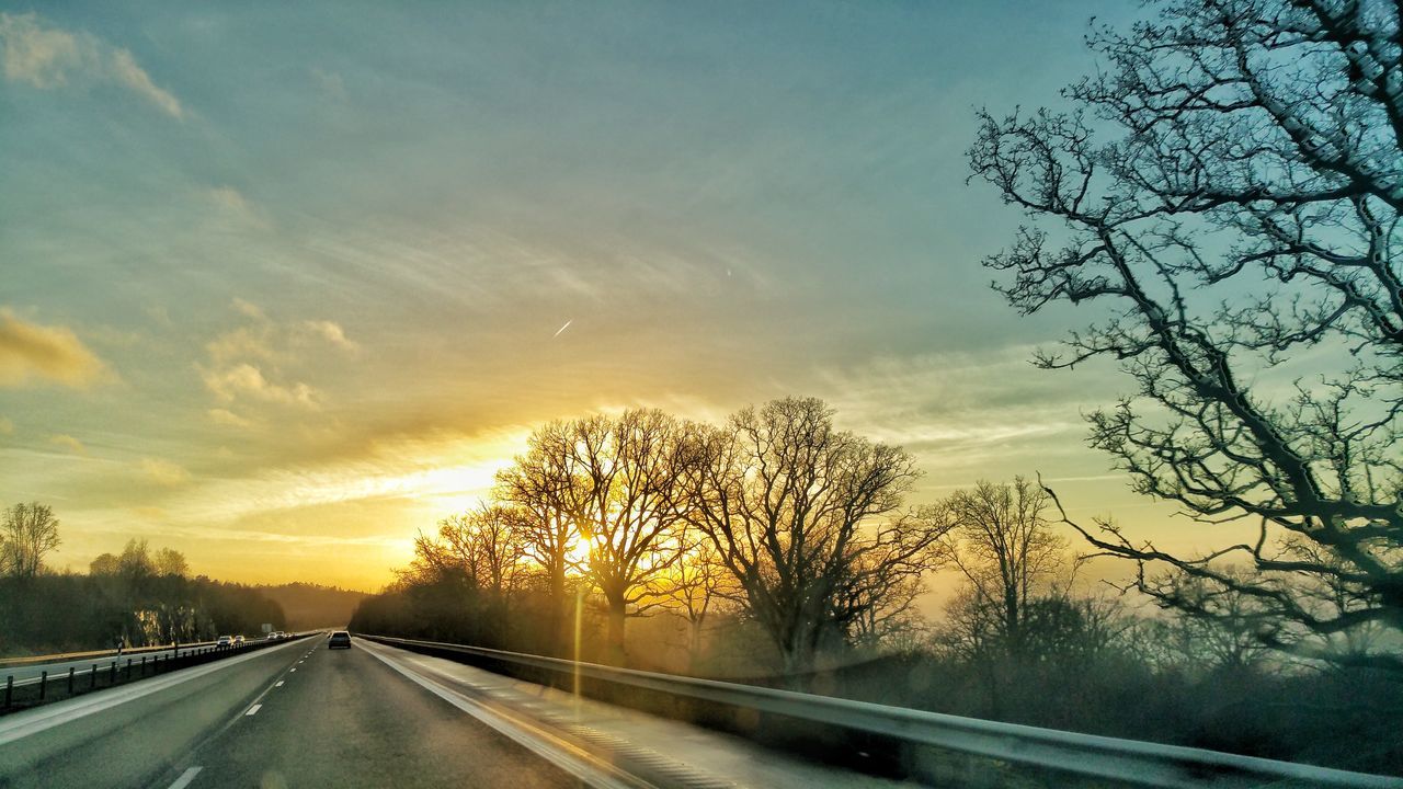 CAR ON ROAD AGAINST SKY DURING SUNSET