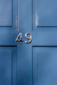 House number 49 on a blue wooden front door in london 