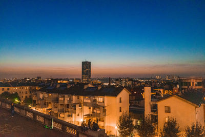 High angle view of illuminated buildings against clear sky at night