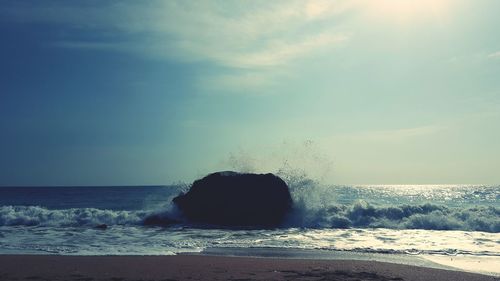 Water splashing in sea against sky