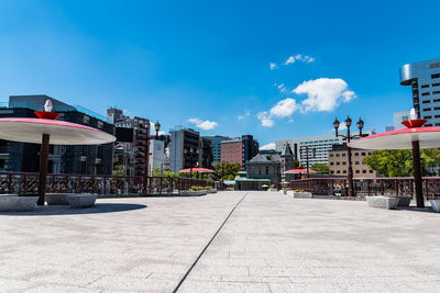 Street amidst buildings against blue sky