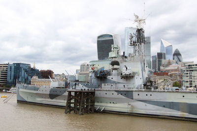 Sailboats moored at harbor in city against sky, ark royal