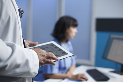 Midsection of man using laptop at office