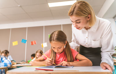 Teacher teaching student at classroom