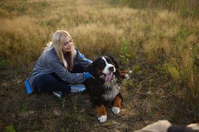 Full length of woman with dog on field