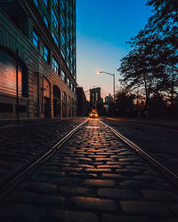 Railroad tracks in city at sunset