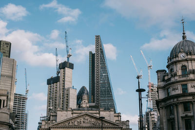 Low angle view of buildings against cloudy sky