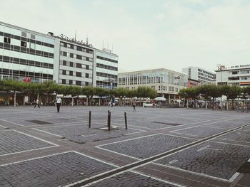 City street by buildings against sky