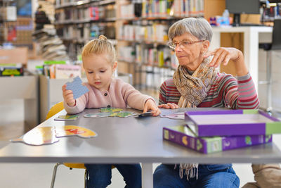 Portrait of smiling woman using digital tablet in library