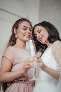 Portrait of smiling young woman drinking glass