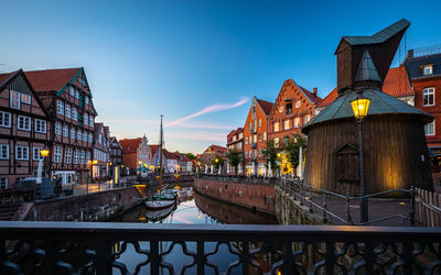 Illuminated buildings against sky at dusk