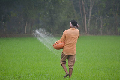 Rear view of man standing on field