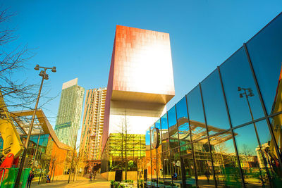 Low angle view of modern buildings against clear blue sky
