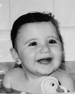 Close-up of cheerful baby girl looking away in bathroom