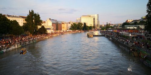 River amidst buildings in city against sky