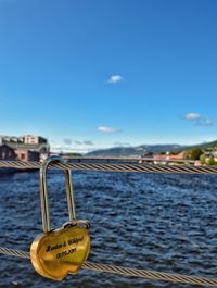 Close-up of padlocks on heart shape against sea