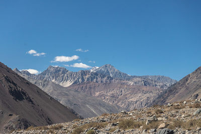 Scenic view of landscape and mountains against blue sky