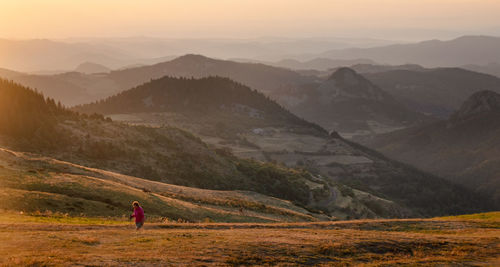 Hiker at sunrise in front of the monts d'ardèche in france