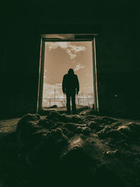 Rear view of man standing against wall