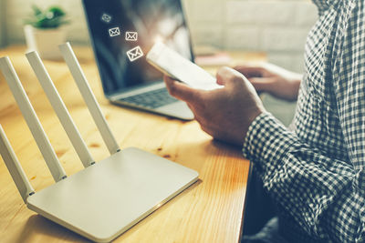 Midsection of man using laptop on table