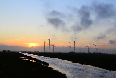 Wind turbine against sky during sunset