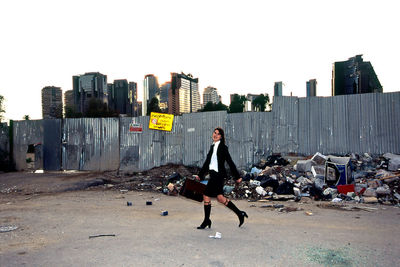 Full length of man and buildings in city against sky