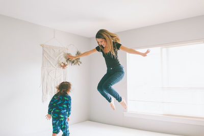 Full length of woman with arms raised at home